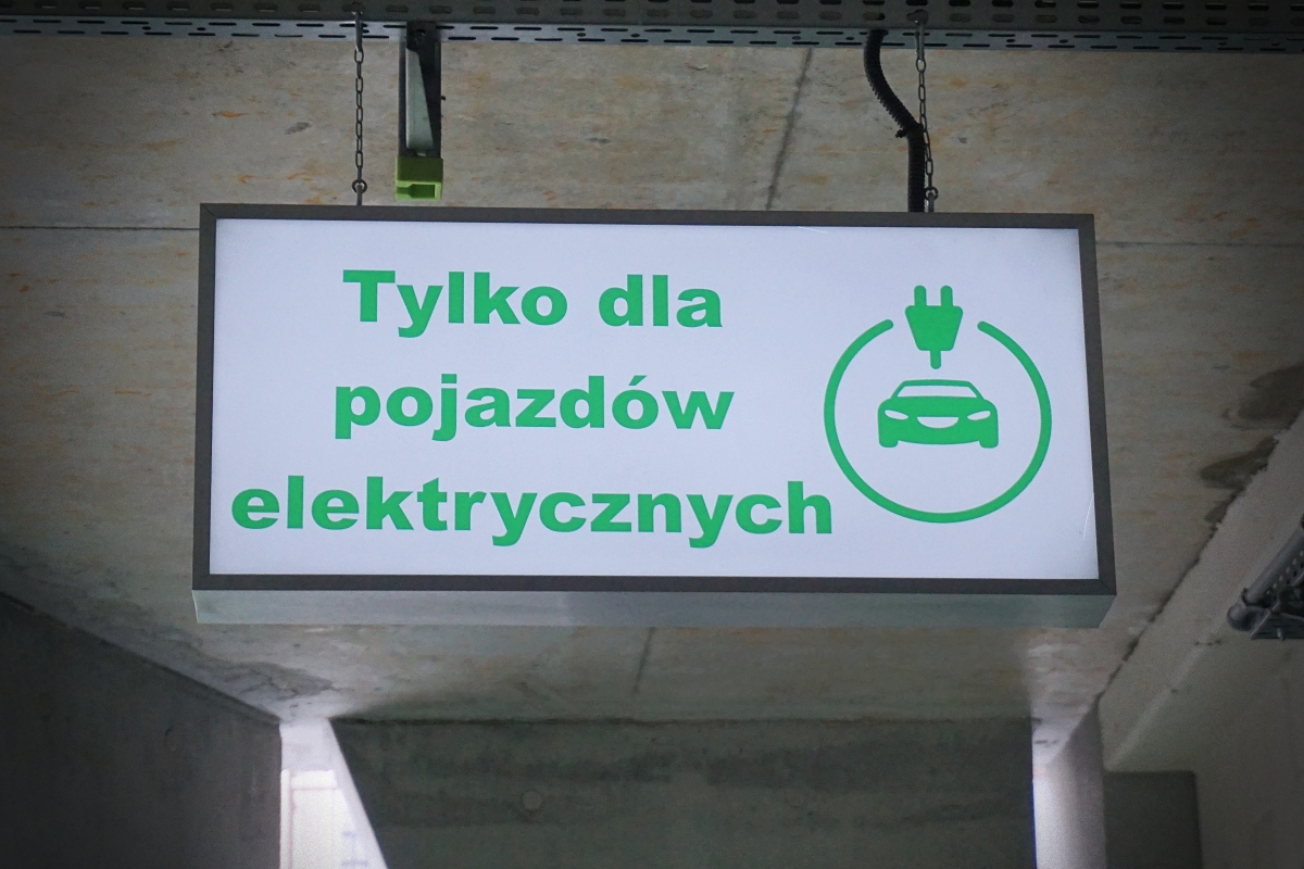 Na zdjęciu widać tablicę informującą o możliwości parkowania wyłącznie pojazdów elektrycznych