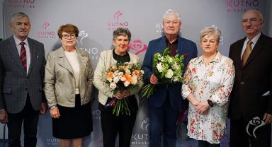 Na zdjęciu widać sześć osób, dwie trzymają kwiaty
