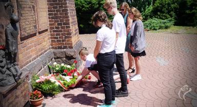Na zdjęciu widać uczniów składających kwiaty