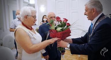 Na zdjęciu widać jak prezydent Kutna wręcza kwiaty jubilatce