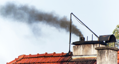 Zdjęcie prezentujące dymiący komin