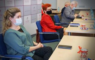 Na zdjęciu widać cztery siedzące osoby, na pierwszym planie dwie kobiety