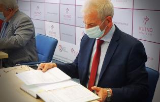 Na zdjęciu widać jedną osobę przeglądającą sprawozdania