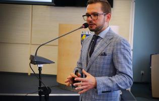 Na zdjęciu widać osobę mówiącą do mikrofonu