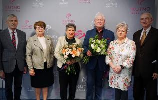 Na zdjęciu widać sześć osób, dwie trzymają kwiaty