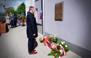 Na zdjęciu widać dwie osoby składające kwiaty