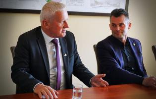 Na zdjęciu widać dwie osoby siedzące przy stole