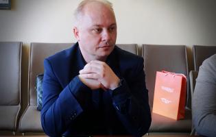 Na zdjęciu widać jedną osobę siedzącą przy stole