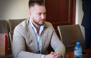 Na zdjęciu widać jedną osobę siedzącą przy stole