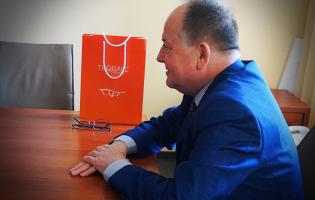 Na zdjęciu widać jedną osobę siedzącą przy stole