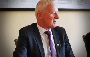 Na zdjęciu widać jedną osobę siedzącą przy stole