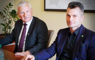 Na zdjęciu widać dwie osoby siedzące przy stole
