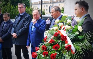 Na zdjęciu widać pięć osób, jedna trzyma kwiaty