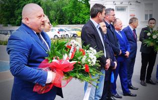 Na zdjęciu widać osiem osób, dwie trzymają kwiaty