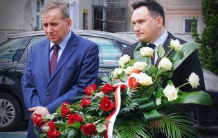 Na zdjęciu widać dwie osoby, jedna trzyma kwiaty