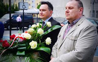 Na zdjęciu widać dwie osoby, jedna trzyma kwiaty