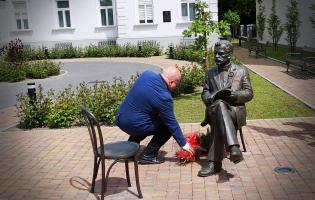 Na zdjęciu widać osobę składającą kwiaty