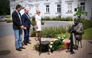 Na zdjęciu widać trzy osoby składające kwiaty