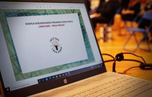 Na zdjęciu widać laptopa z otwartą prezentacją