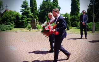 Na zdjęciu widać dwie osoby składające kwiaty
