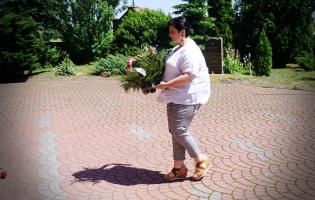 Na zdjęciu widać jedną osobę składającą kwiaty