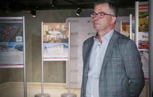 Na zdjęciu widać jedną osobę stojącą przy wystawie