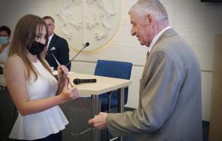 Na zdjęciu widać dwie osoby podczas nagradzania 