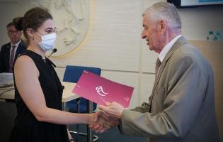 Na zdjęciu widać dwie osoby podczas nagradzania 