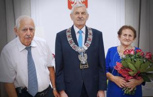 Na zdjęciu widać trzy osoby pozujące do zdjęcia