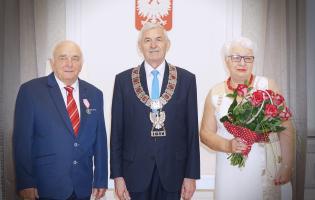 Na zdjęciu widać trzy osoby pozujące do zdjęcia