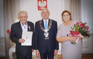 Na zdjęciu widać trzy osoby pozujące do zdjęcia